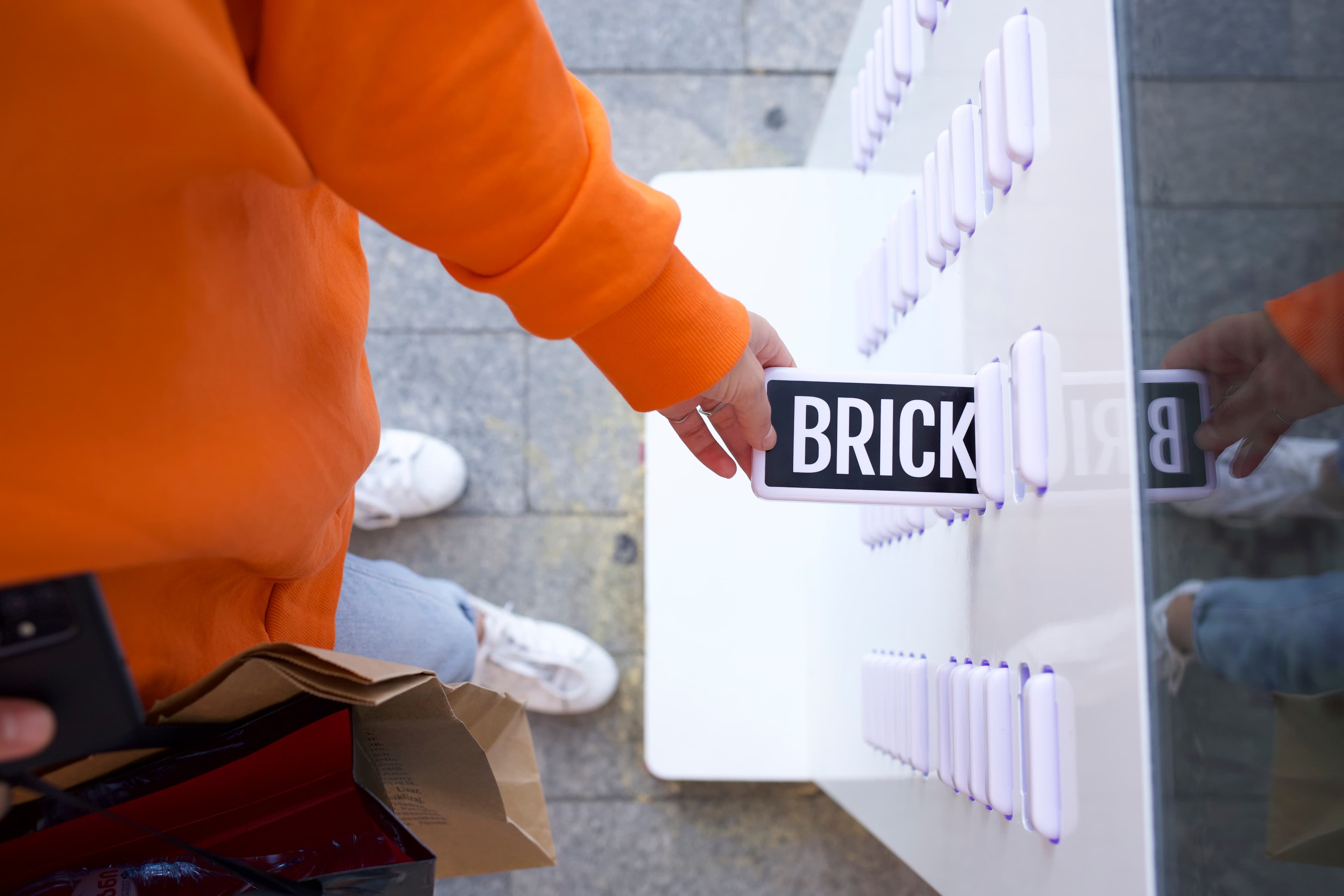 Una mano che prende un power bank Brick da una stazione di servizio